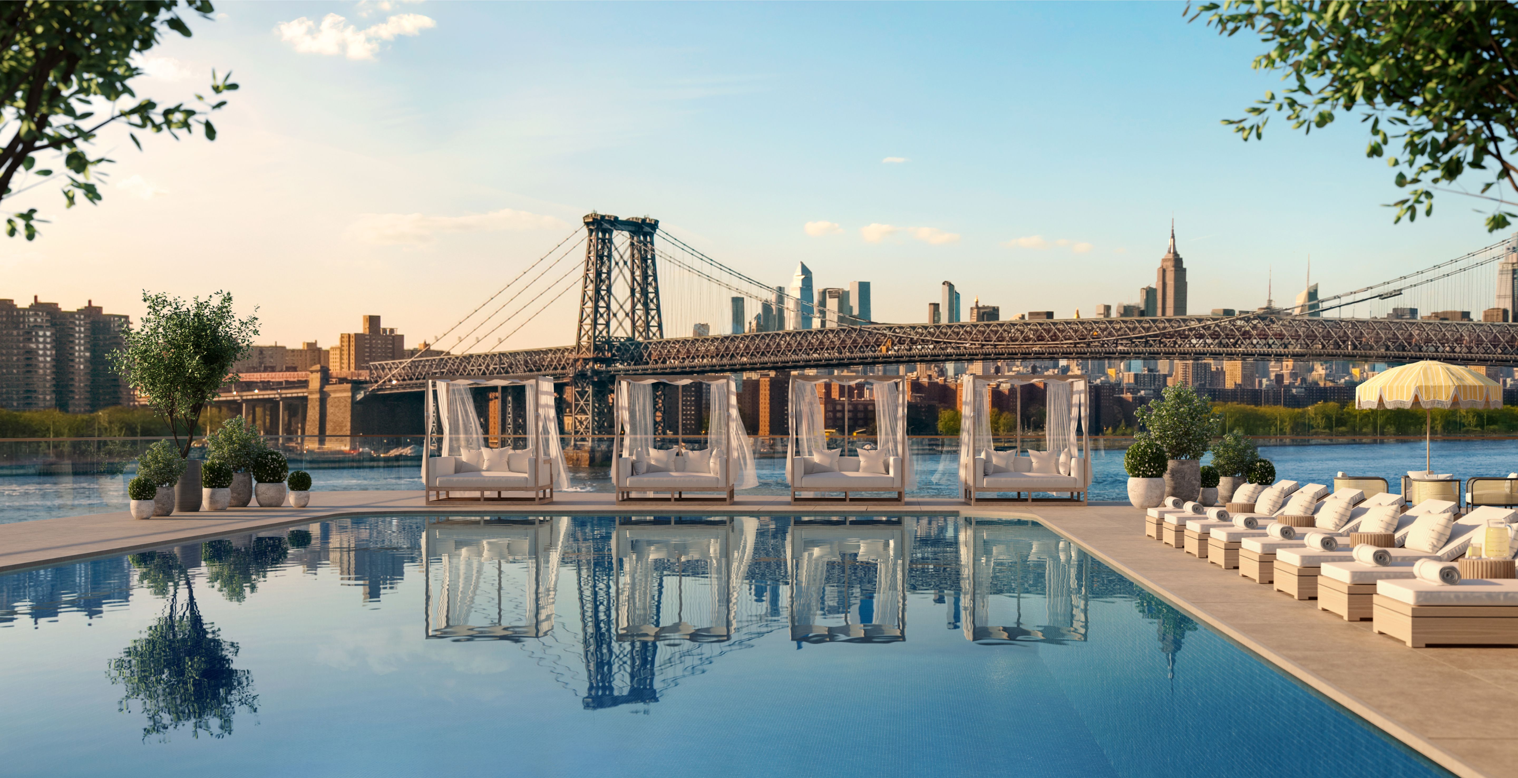 Outdoor pool with daybed cabanas and lounge chairs at the luxurious Williamsburg Wharf Resort & Recreation Club, overlooking Brooklyn’s East River.