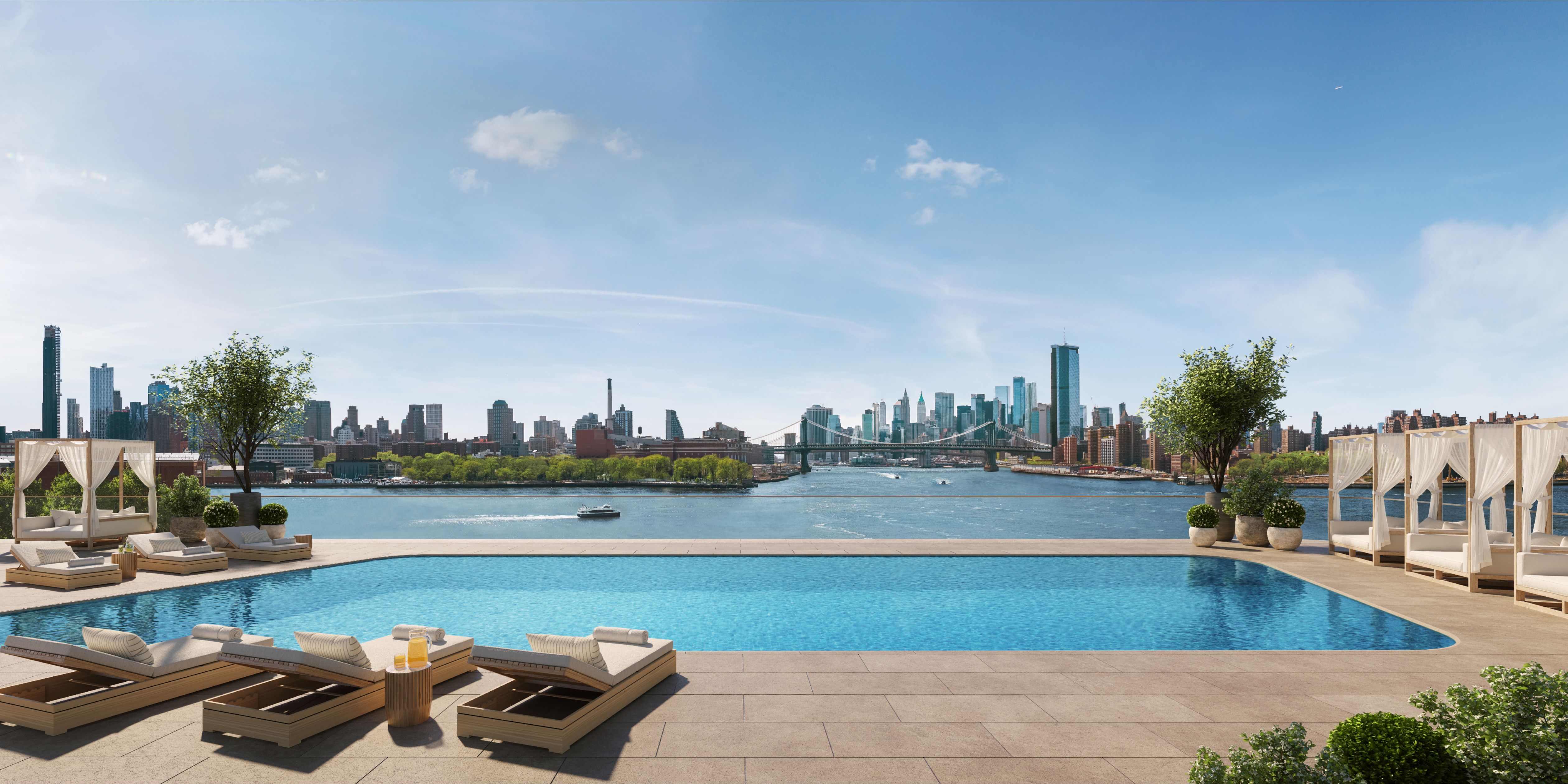 Rooftop pool terrace at the Williamsburg Wharf Resort & Recreation Club with lounge seating and views of the East River and Manhattan skyline.