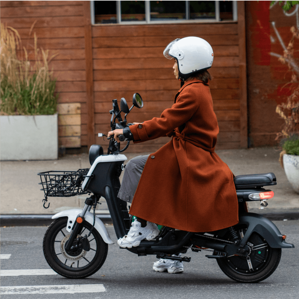 Woman in long jacket riding a scooter - Fashion in Williamsburg, Brooklyn