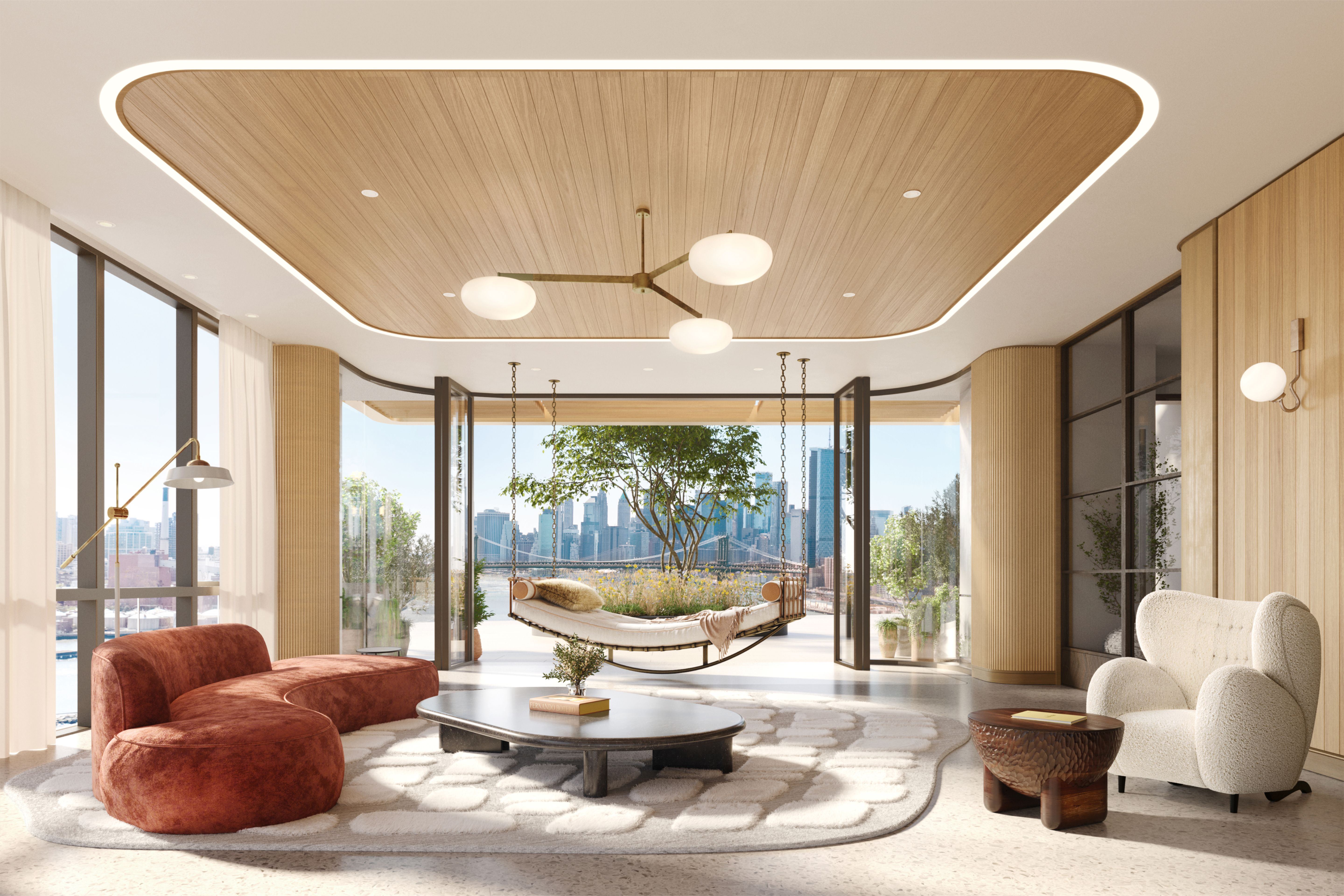 Contemporary club lounge area with modern furniture at the Williamsburg Wharf Resort & Recreation Club, featuring natural light and views of the Manhattan skyline.