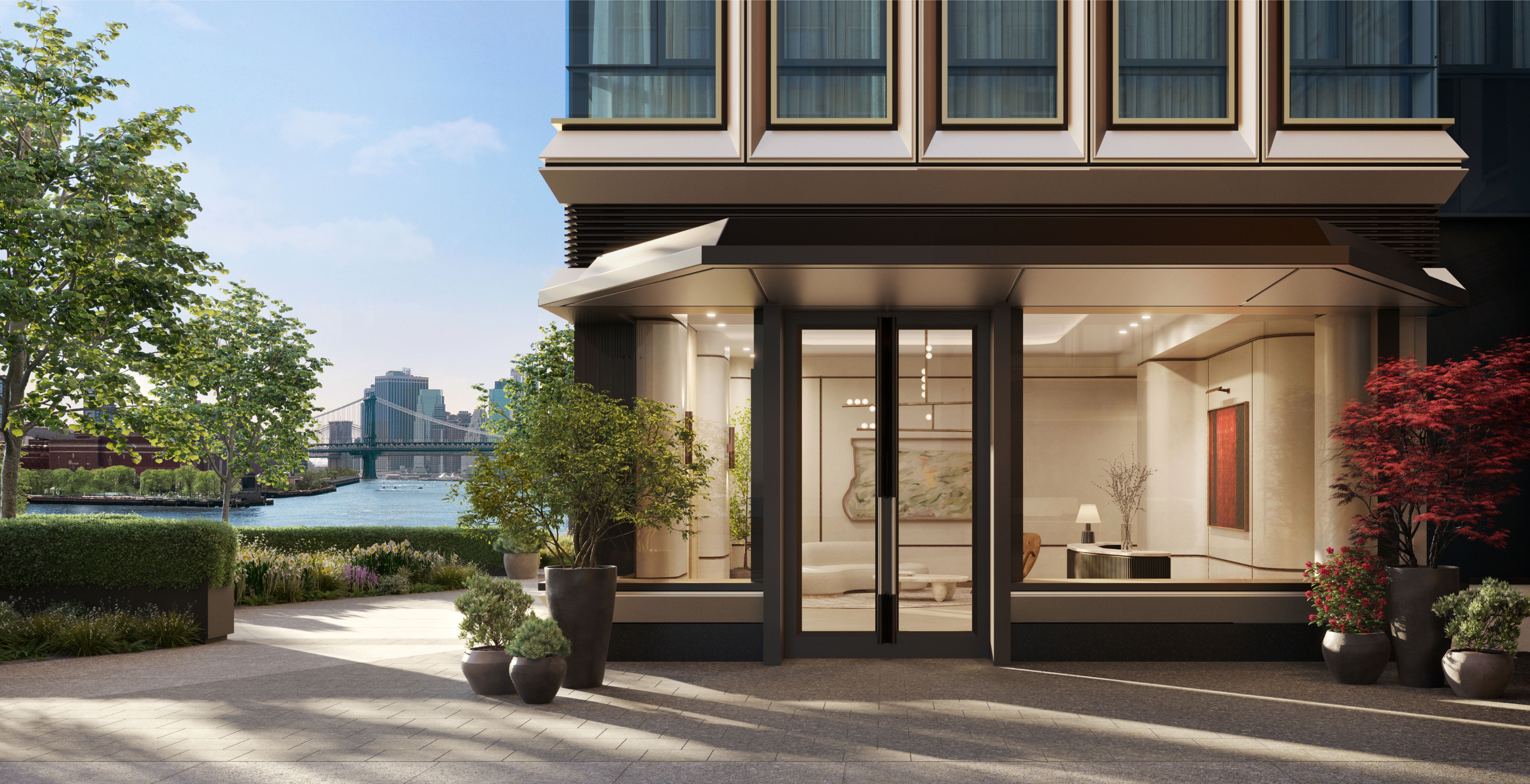 Elegant entrance and lobby of One Williamsburg Wharf luxury condominiums in Brooklyn, with views of the East River and Williamsburg Bridge.