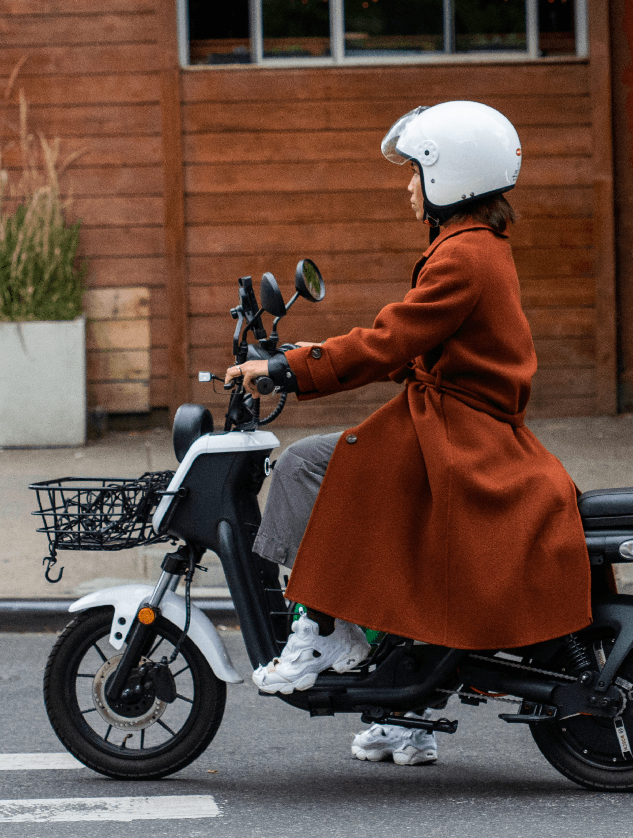 Woman in long jacket riding a scooter - Fashion in Williamsburg, Brooklyn